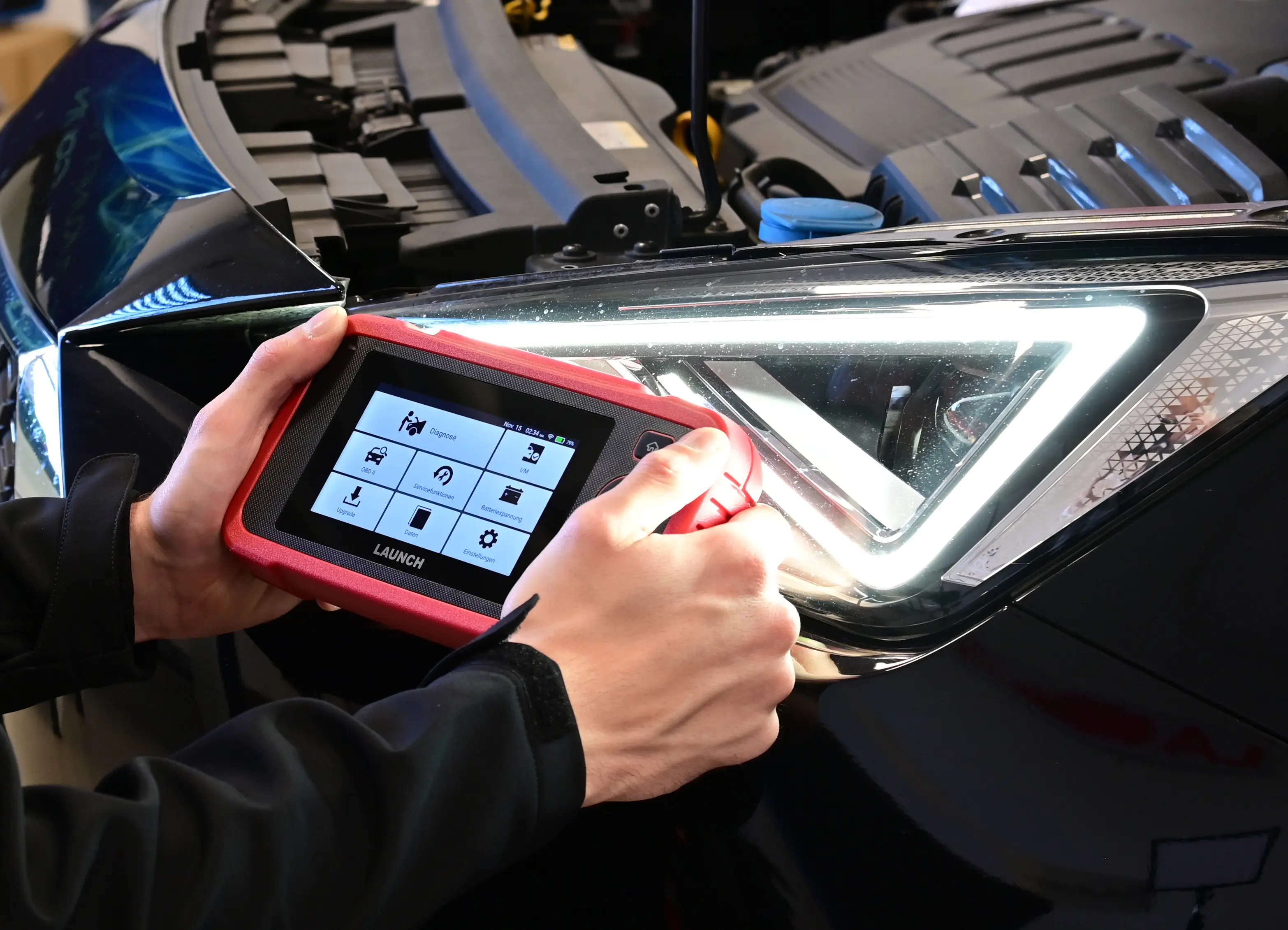 LAUNCH Code Reader for Car being used to diagnose a vehicle in a modern workshop.