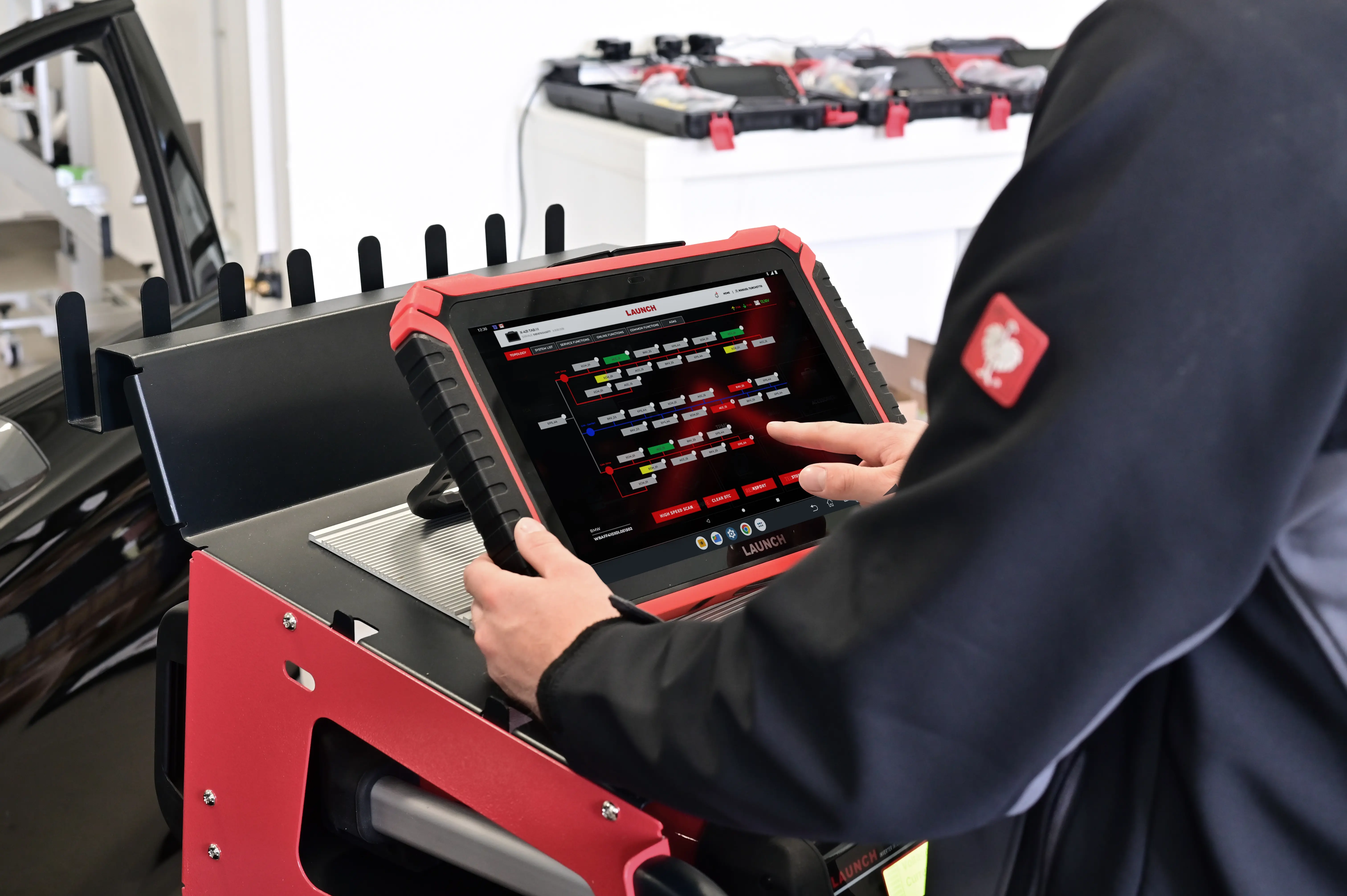 A man working in a garage using one of the best car code readers.