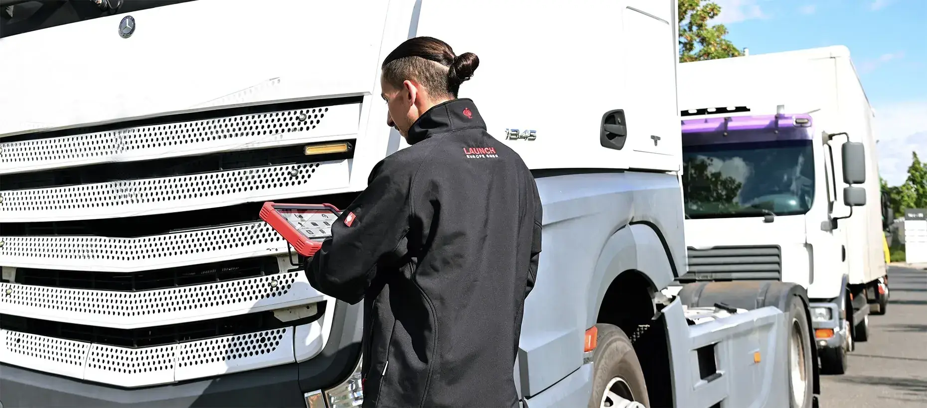 A technician using truck diagnostics equipment to identify faults on a commercial vehicle and help reduce fleet downtime.