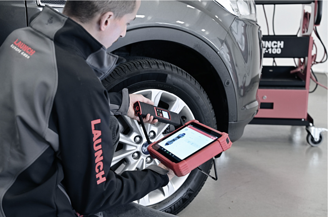 Technician using a car diagnostic tool to perform vehicle diagnostics and fault detection.