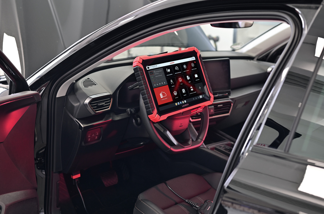 Launch X-431 Euro diagnostic tablet connected inside a vehicle cabin for advanced automotive diagnostics and system analysis.