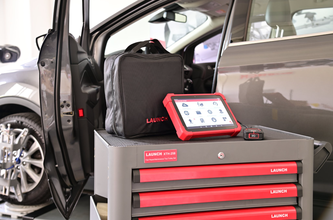 Car code reader placed outside a vehicle used for checking engine fault codes during diagnostics.