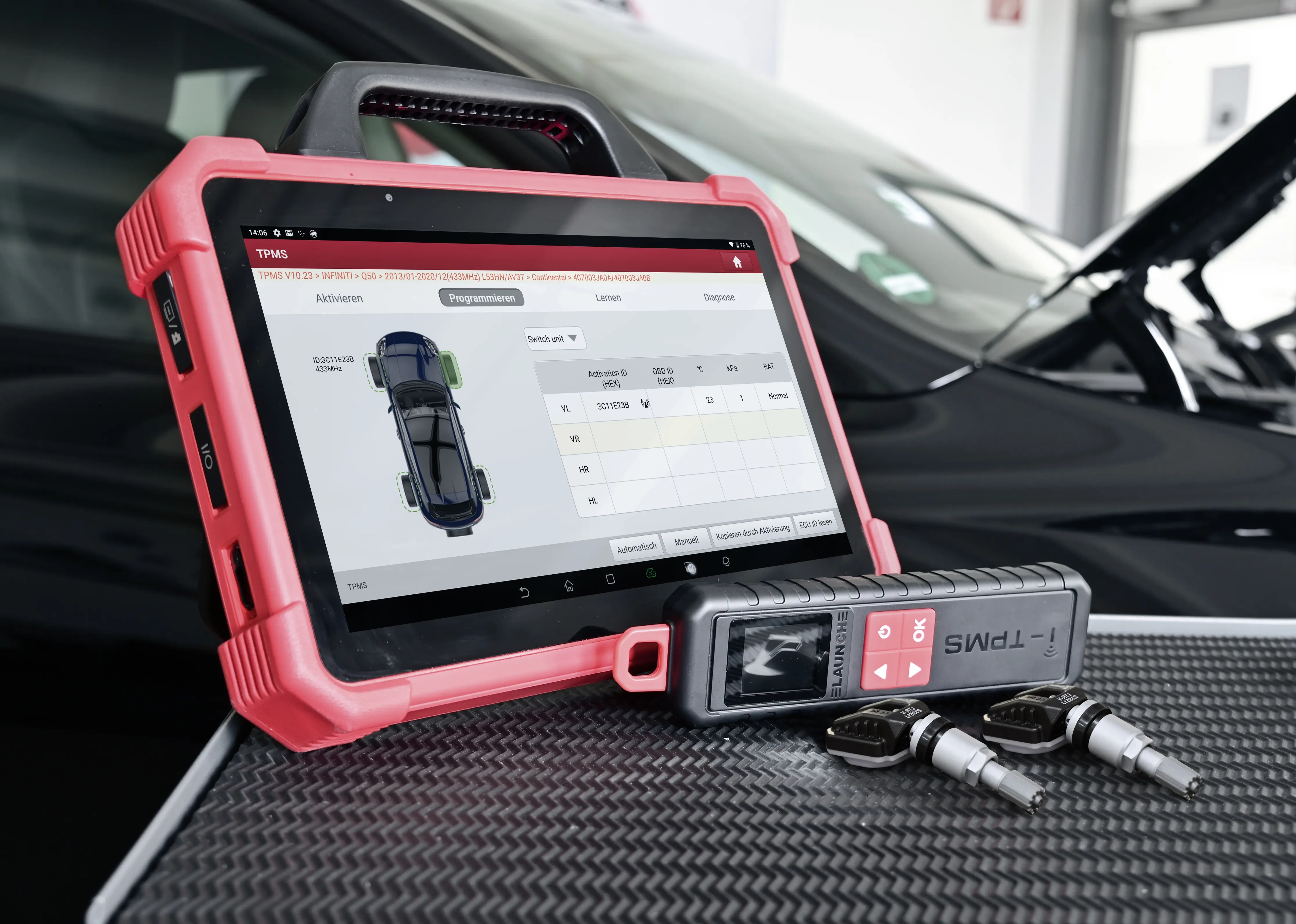A diagnostic tablet and replacement sensors being used for a TPMS Sensor Replacement in a professional garage.