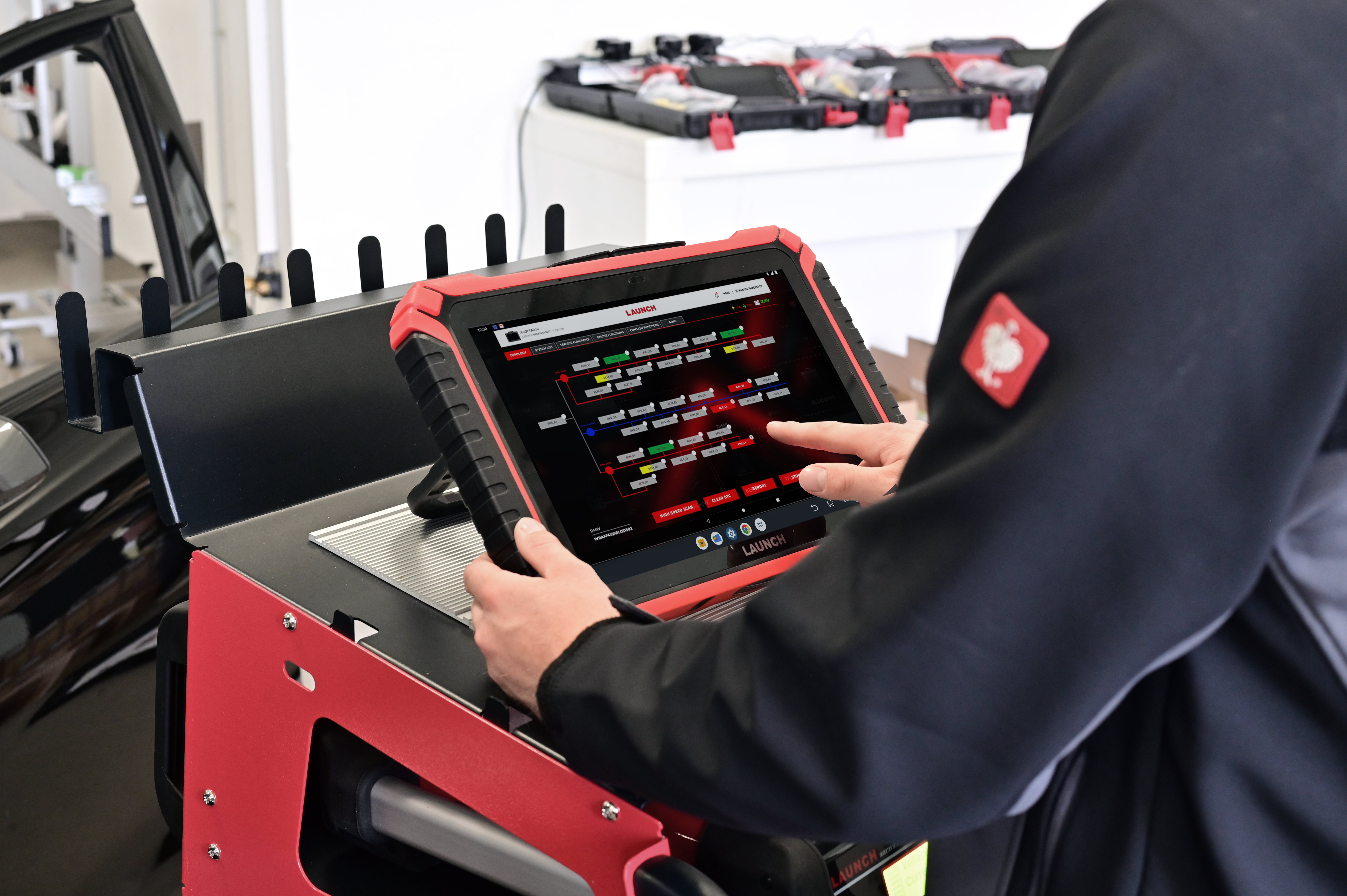 Technician using a Launch diagnostic tablet to review vehicle system topology, supporting accurate diagnostics alongside high-quality ATF fluid in transmission servicing.