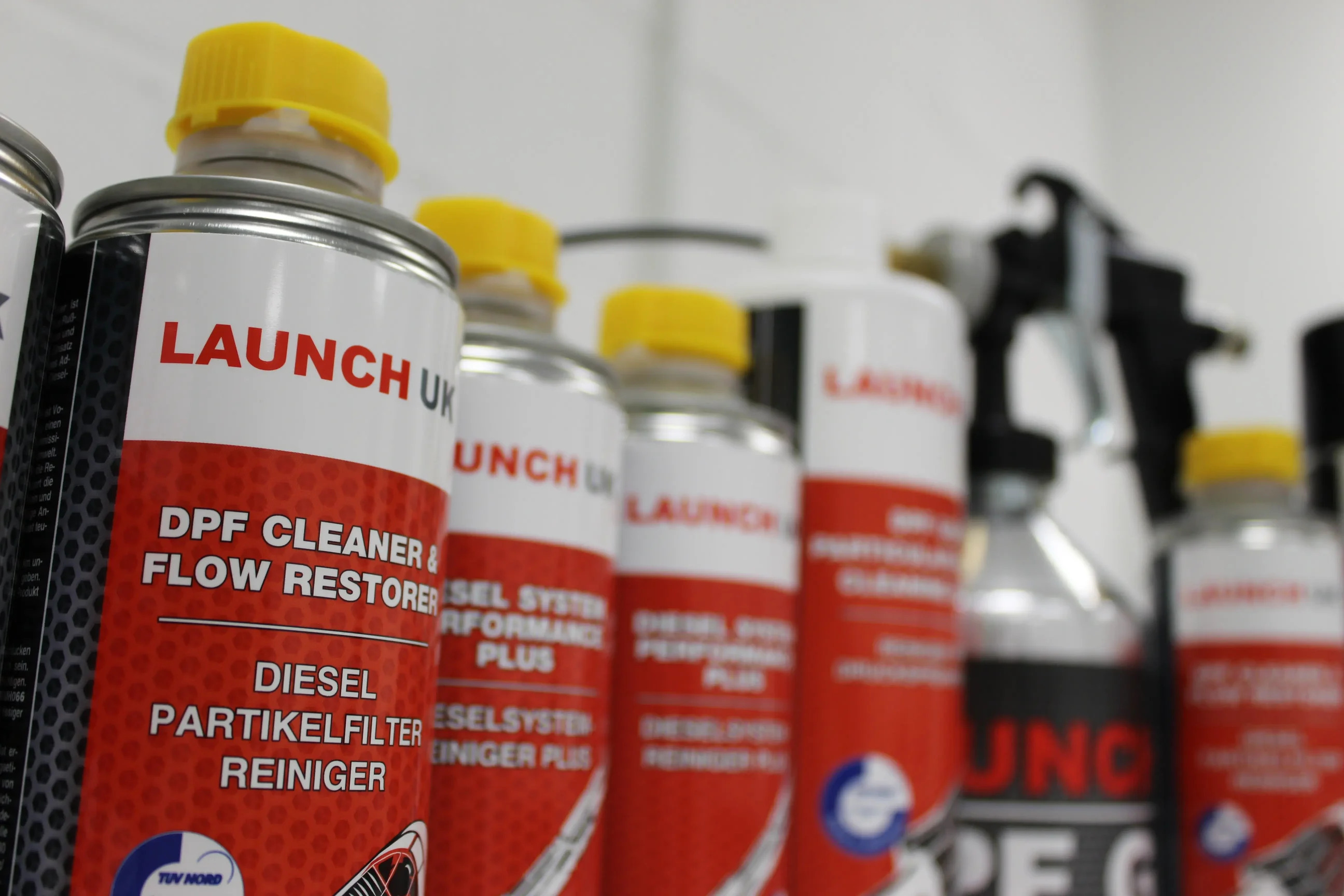 Launch UK DPF cleaner and diesel system performance cans alongside a DPF cleaning gun, illustrating what DPF fluid is made from in professional workshop products.